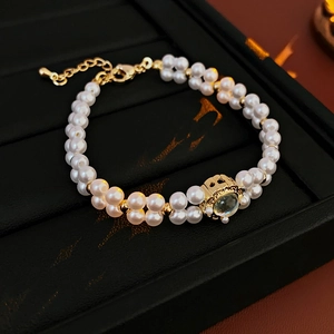 Detail of double-layer pearl bracelet with fishtail moonstone and gold-plated crown setting