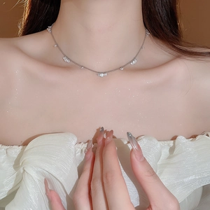 Close-up of a silver necklace with sparkling cubic zirconia on a model's neck