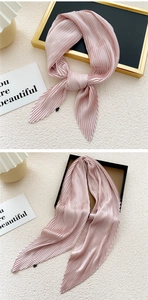 Detailed view of pink pleated silk scarf displayed in elegant knots and hanging styles