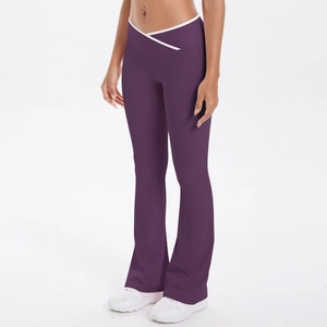 Detail view of high-waisted dark purple flare yoga pants with white piping cross waist