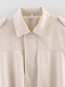 Detailed close-up of beige suede aviator jacket featuring lapel collar and shoulder epaulettes