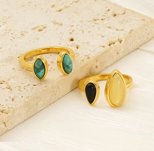 Détail de bagues ajustables plaquées or 18 carats avec pierres vertes et noires incrustées