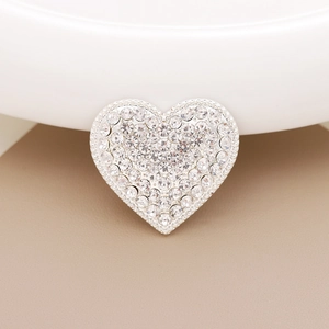 Macro detail of heart-shaped charm with sparkling rhinestones for DIY shoe and phone decor