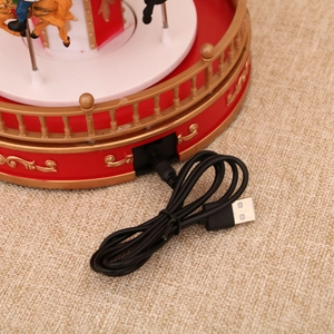 Detail of the carousel music box base showing the USB power port and red gold finish