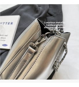 Detailed close-up of silver metallic bucket bag with premium chain strap and sleek texture