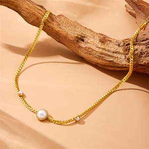 Elegant gold snake chain necklace with pearl and diamond pendant on a branch