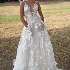 Elegant white lace A-line wedding dress with deep V-neck and floral appliques