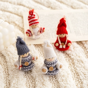 Detailed view of handmade knitted Christmas gnome ornaments with hats and wooden buttons
