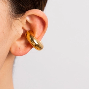 Close-up of a wide polished 18K gold-plated stainless steel textured C-shaped ear cuff