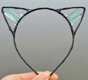Close-up of handmade cat ear headband with green crystals and wire-wrapped detail