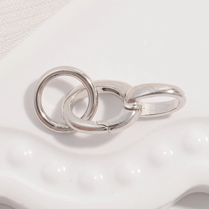 Macro shot of S925 sterling silver U-shaped horseshoe spring clasp on white ceramic plate