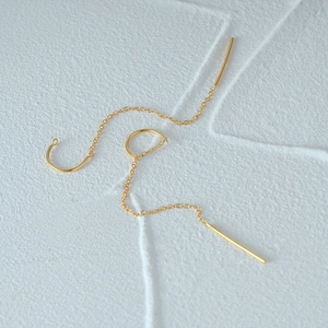 Close-up of elegant gold plated S925 sterling silver chain earrings on a white surface