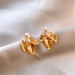 French vintage gold leaf earrings with white pearls and crystals on silk background