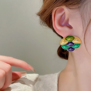 Detailed view of colorful enamel earrings in an artistic retro fish-scale layered design