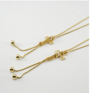 Detail of 18K gold plated titanium cross pendant with adjustable bead chain and slide clasp