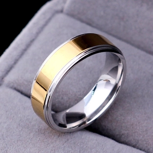 Macro detail of 316L stainless steel two-tone gold and silver ring on grey velvet stand