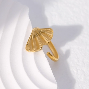 Detail shot of golden ginkgo leaf adjustable ring on a white minimalist background