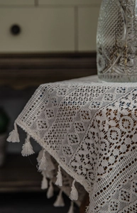 Detail of beige crochet lace curtain with fringe edge and retro hollow texture