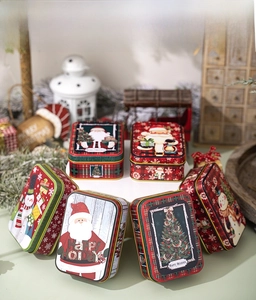 Various Christmas tin boxes with festive Santa and snowman patterns in a cozy display