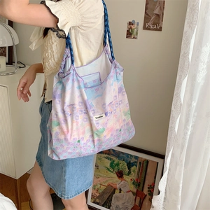 Artistic oil painting floral tote bag with blue woven drawstring straps shown on model