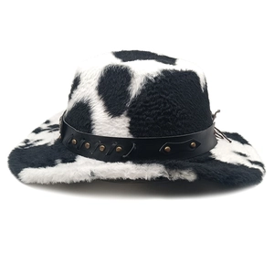 Detail of plush cow print cowboy hat with black leather band and metal rivets