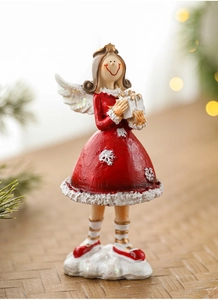 Close-up of a red resin Christmas angel figurine with festive wood and pine background