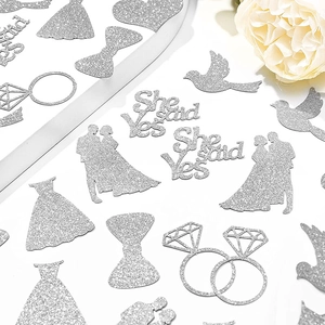 Silver glitter wedding confetti including ring and She Said Yes shapes on white background
