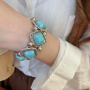 Close-up of a silver vintage bohemian bracelet with green stone inlay on a wrist