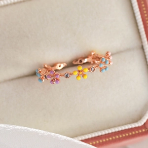 Macro detail of colorful enamel flowers and zircons on rose gold open ring