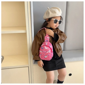 Pink kids crossbody bag with cartoon unicorn patterns shown on a young girl model