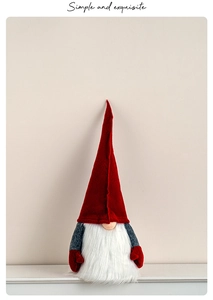 Close-up of a handmade red knitted Christmas gnome with a long white plush beard