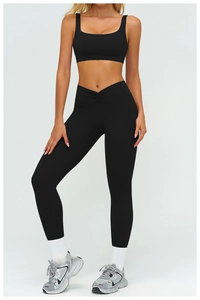Detail of high-waist black sports leggings with V-shaped crossover waist design