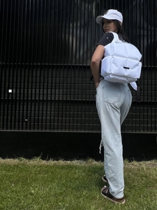 Vue détaillée du sac à dos matelassé blanc avec bandoulière rembourrée et poche avant