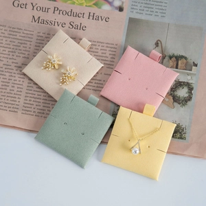 Macro detail of microfiber jewelry display cards in various colors with multi-hole design