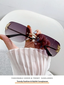 Detail of rimless sunglasses with purple gradient lenses and gold butterfly accents