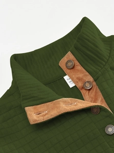 Detail of olive green waffle knit texture and brown faux suede trim with metallic buttons