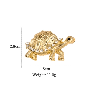 Vue détaillée d'une broche tortue dorée avec strass et dimensions du produit