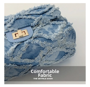 Close-up of distressed denim small square bag with quilted pattern and gold turn-lock