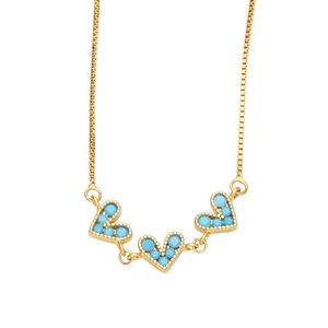 Detail of gold box chain necklace featuring three blue turquoise heart-shaped pendants