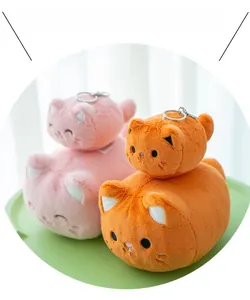 Macro shot of cute plush cat keychains in pink and orange colors with secure metal rings
