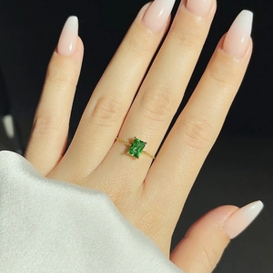 Macro view of emerald-cut green zircon ring with 18K gold plated adjustable chain band