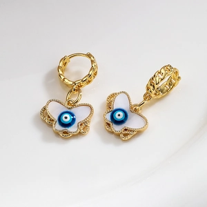 Gold plated butterfly drop earrings with evil eye design on white background
