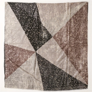 Detail view of cotton-linen feel scarf with geometric triangles and gold foil linear print
