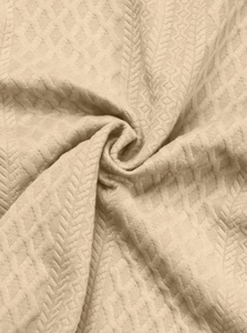 Detailed close-up of khaki waffle and herringbone knit texture on a men's polo shirt