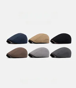 Flat lay of cotton linen flat caps in six colors including navy, khaki, and grey tones