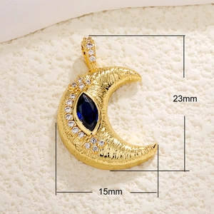 Macro view of gold-plated moon pendant with blue center stone and zircon accents