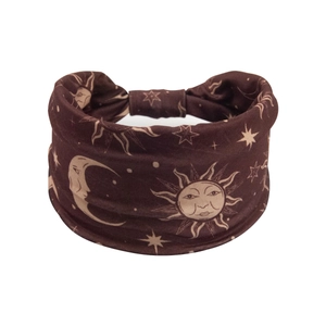Detail of bohemian wide headband with sun and moon celestial prints on soft brown fabric