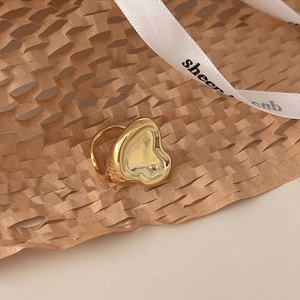 Macro shot of an irregular gold-finished sterling silver ring on a honeycomb paper texture