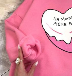 Détail de la doublure en polaire chaude et du motif cœur sur ce sweat-shirt rose