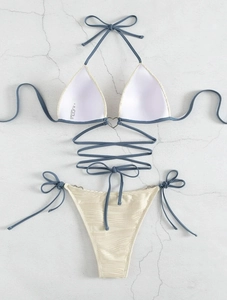 Detail of bikini top with heart-shaped metal link and long criss-cross waist straps